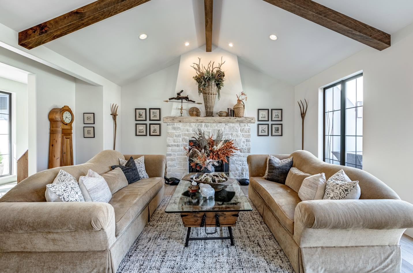 Living room with exposed wood beams and floor to ceiling windows on the Home Tour