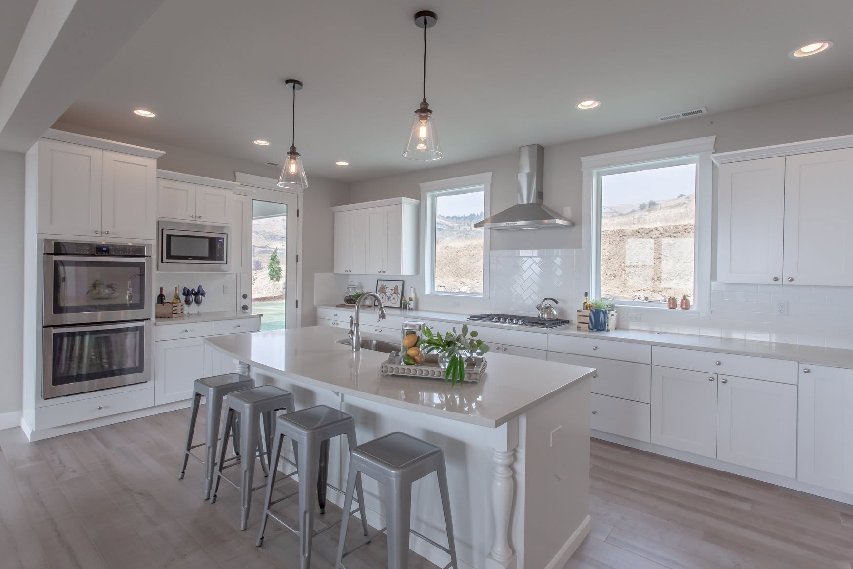 White shaker kitchen with large island and pendant lighting in a Home Tour house